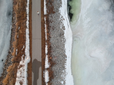 Woman running on a path through a lake